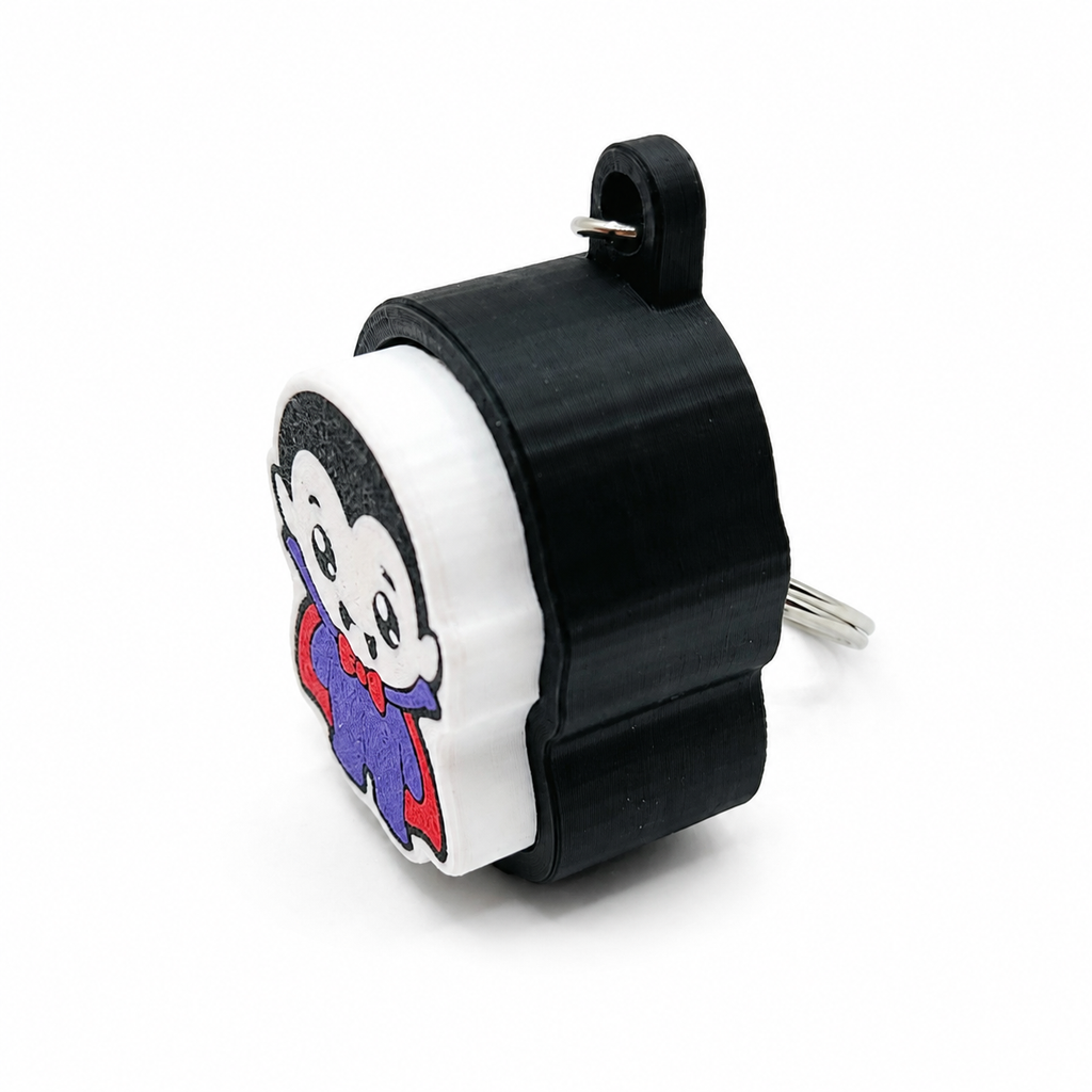 Side view of the black and white 3D-printed vampire clicker keychain showing its fidget mechanism and keychain loop.